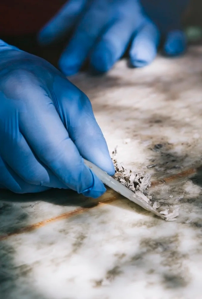 Fachgerechte Probenahme eines Baustoffs zur Asbestuntersuchung auf einer Baustelle